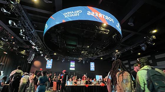 Fish-eye view of the Student Resource Fair. Several lines of booths are set up and many students are walking around the venue.