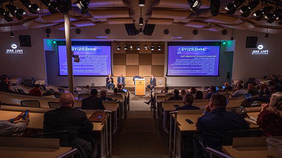 An audience watches a group of panelists give a presentation on stage at Central Florida's Second Annual Immersive Technology Summit.